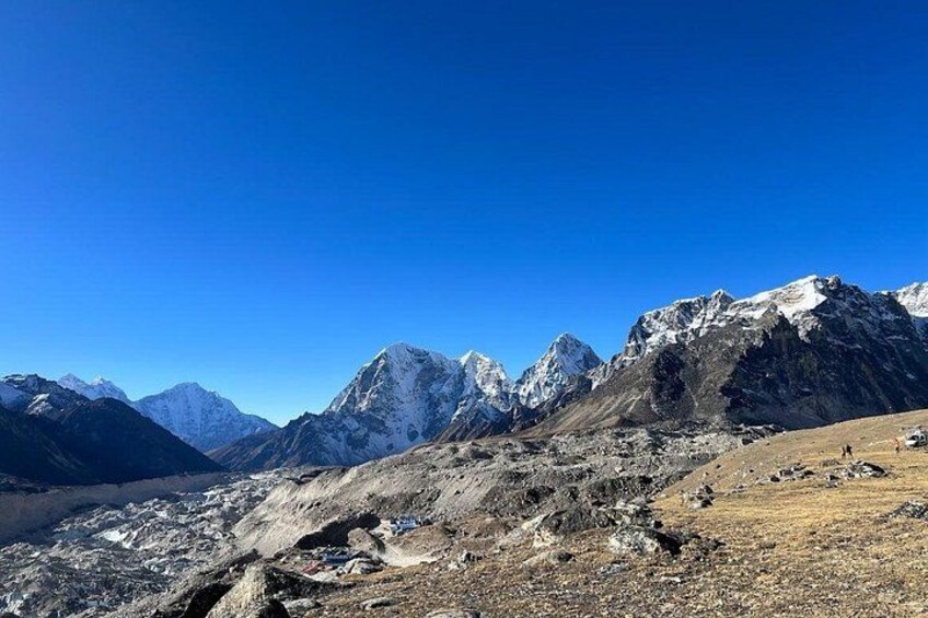 A mountainous landscape with snow-capped peaks under a clear blue sky. 2