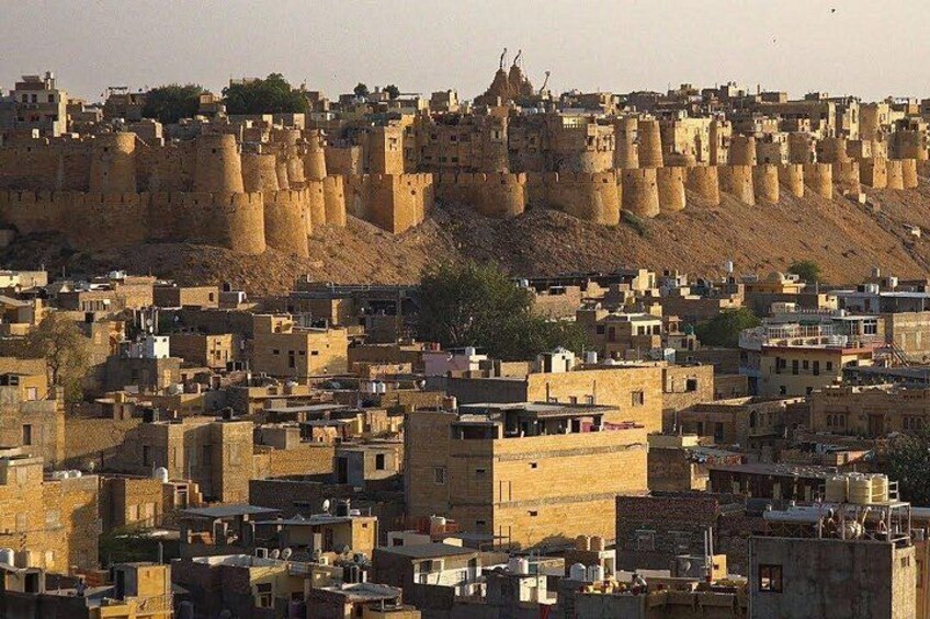 A cityscape with a prominent fortress-like structure in the background. 1