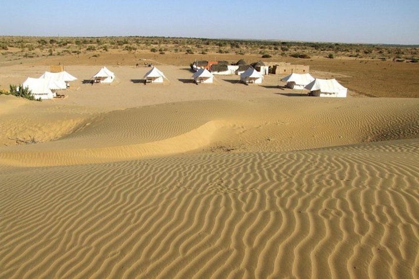 Paisaje desértico con tiendas blancas y dunas de arena. 1