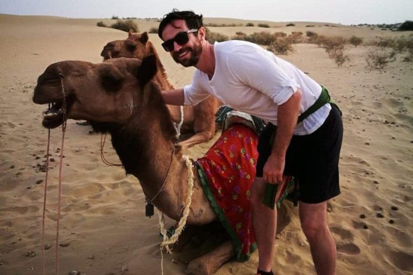 A person riding a camel in a desert. 1