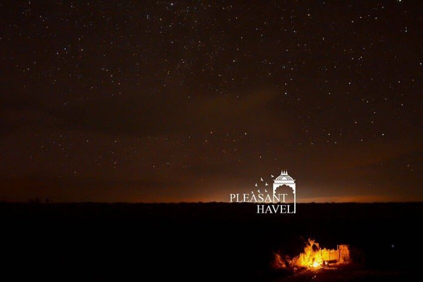 Nattehimmel med stjerner, et lejrbål og silhuetten af en bygning med teksten 'PLEASANT HAVEL' 2