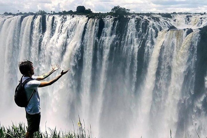 Iemand staat voor een grote waterval. 5