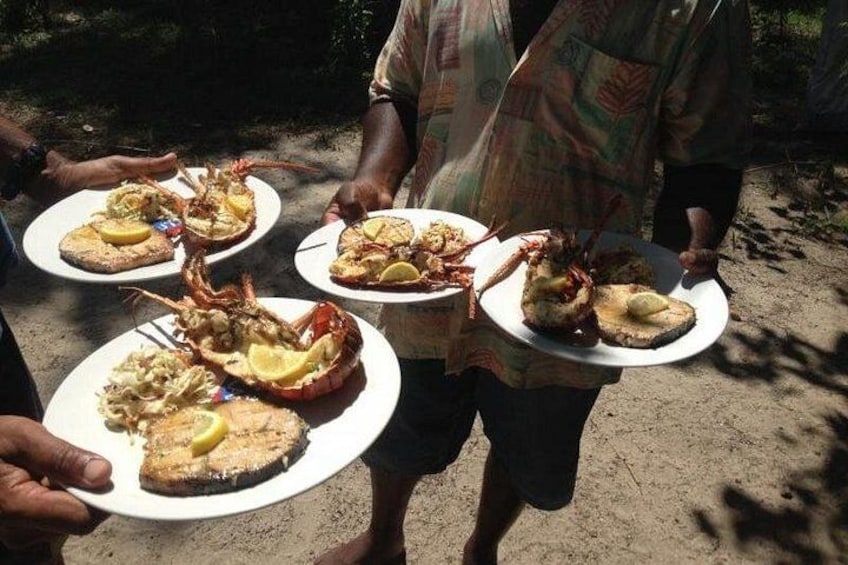 People holding plates with seafood dishes outdoors. 5