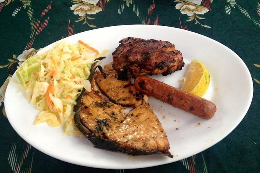 A plate with grilled meat, sausage, and coleslaw. 2