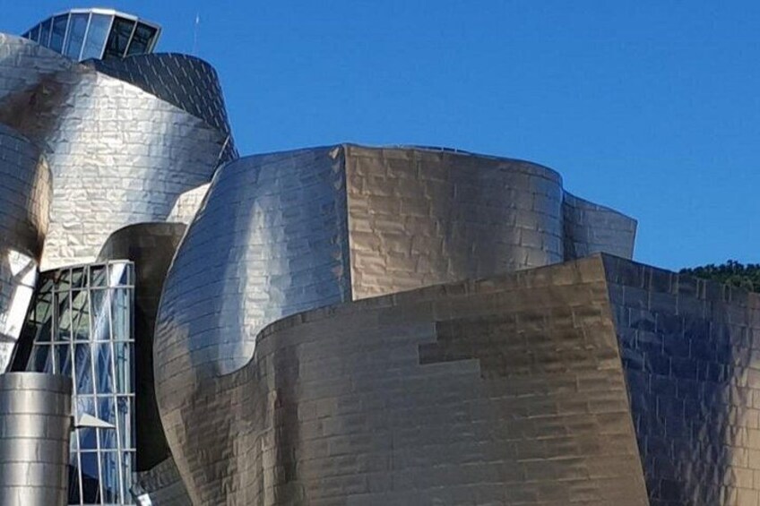 Eine moderne Architektur mit einer metallischen, geschwungenen Fassade. 4