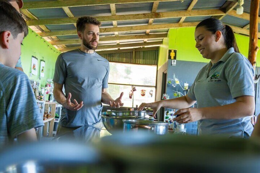 A person cooking in a kitchen with a green wall and wooden ceiling. 2