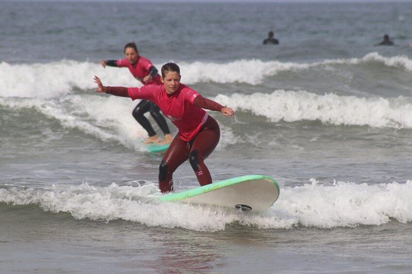 Two surfers riding waves in the ocean. 3