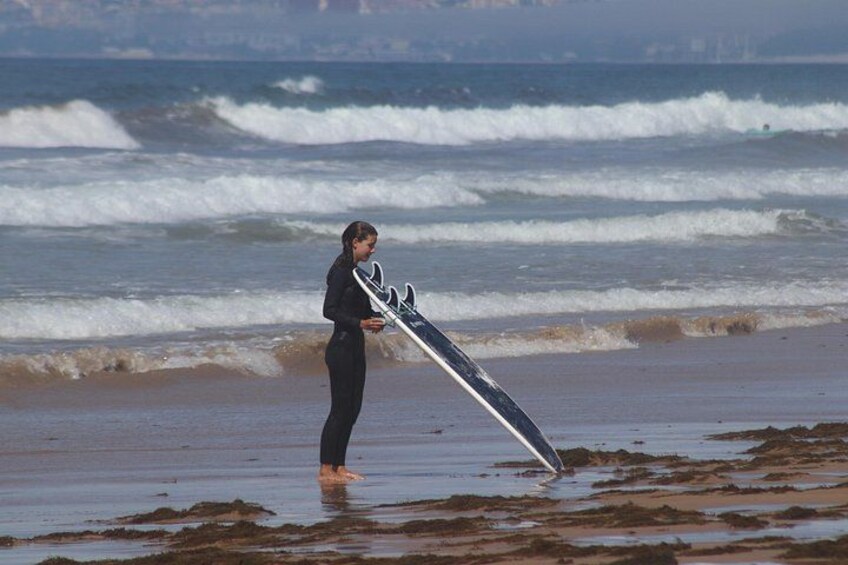 A person holding a surfboard on a beach with waves. 4
