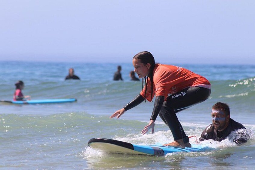 A person surfing on a wave with another person in the water. 5