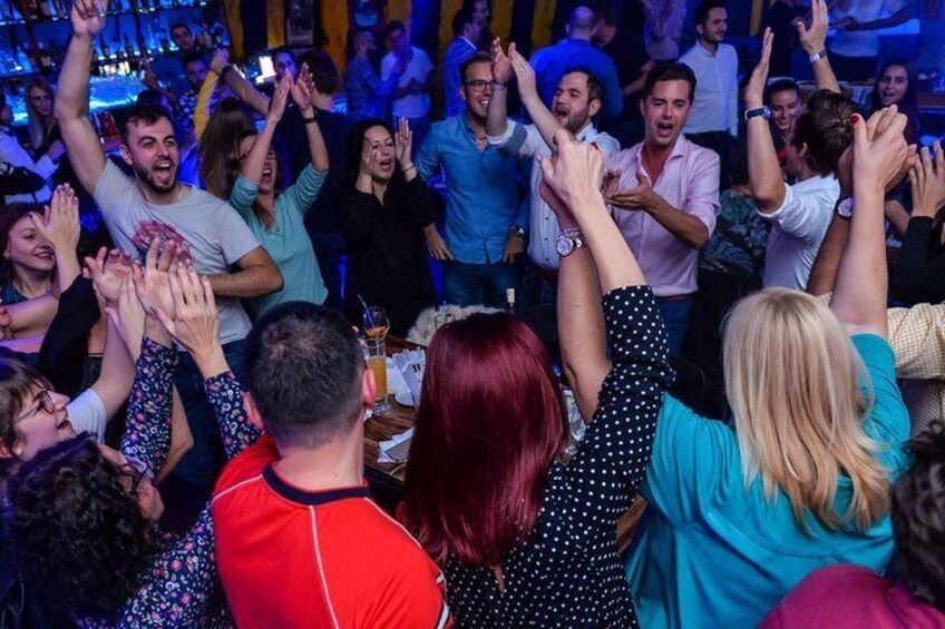Un bar concurrido donde la gente levanta las manos. 4