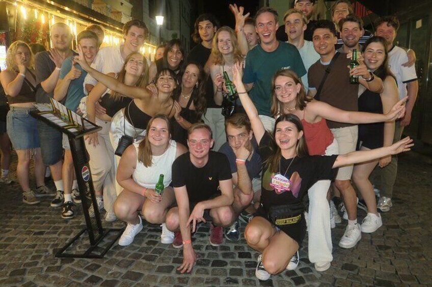 Un grupo de personas posando para una foto en un entorno al aire libre con suelo adoquinado. 2