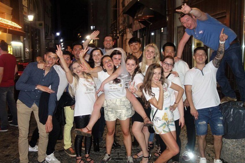 Een groep mensen die 's nachts op een straat een foto maakt. 5