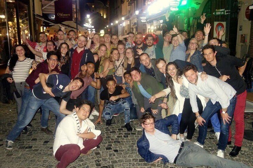 Un grupo de personas posando en una calle adoquinada de noche. 3