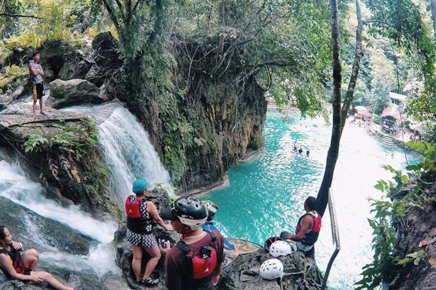 A waterfall, a river, and people engaging in water activities. 1