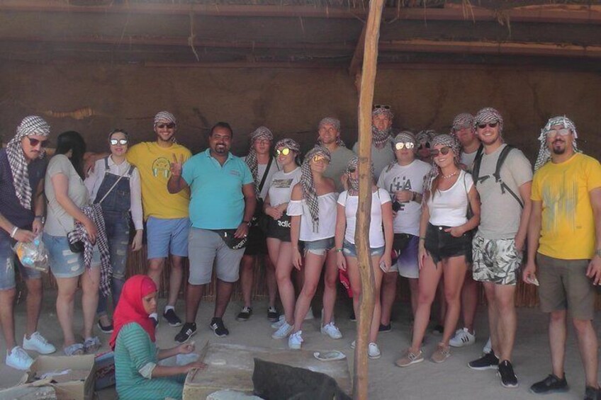 Un grupo de personas de pie en un entorno rústico al aire libre, posiblemente un campamento o una zona de mercado. 5