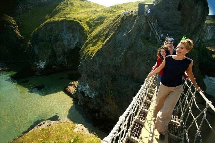 A rope bridge over a river with rocky cliffs and a clear sky. 3