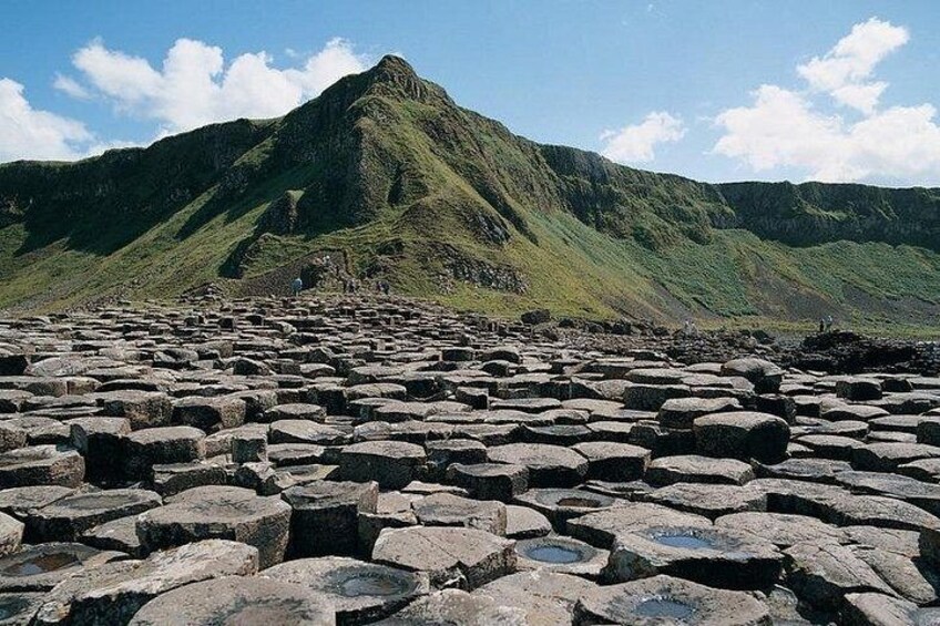 A landscape with a large hill and a field of hexagonal basalt columns. 3