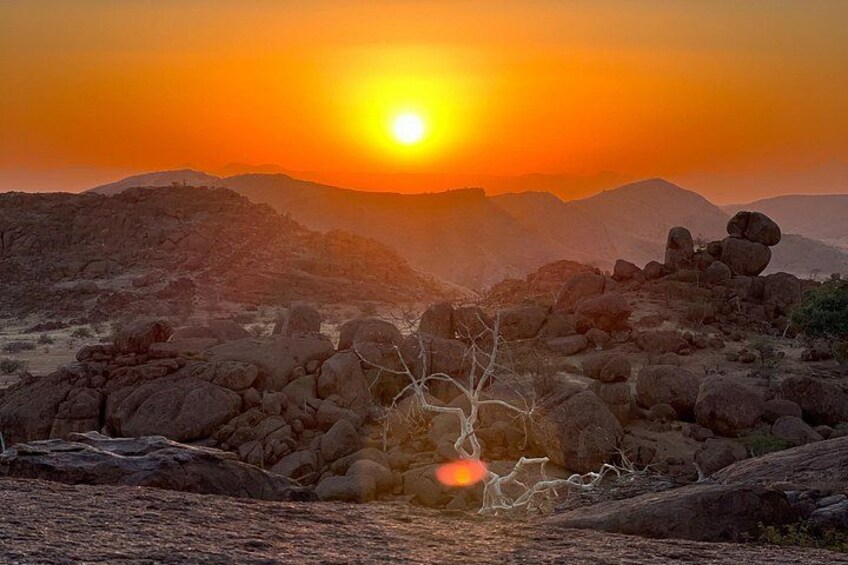 A sunset over rocky terrain with a clear sky. 2