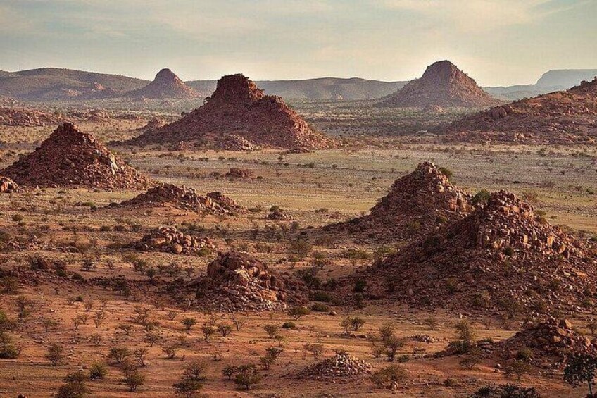 A desert landscape with rocky formations and sparse vegetation. 4
