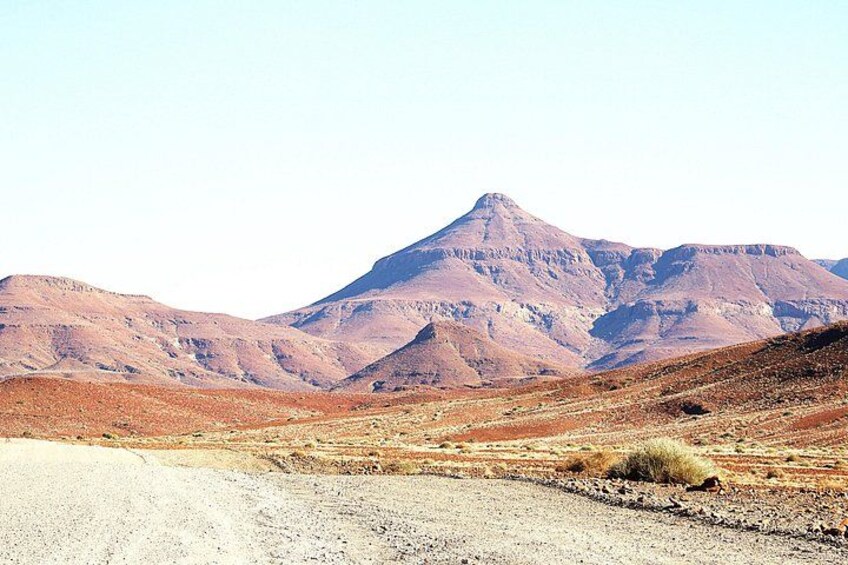 A desert landscape with a prominent mountain in the background. 3