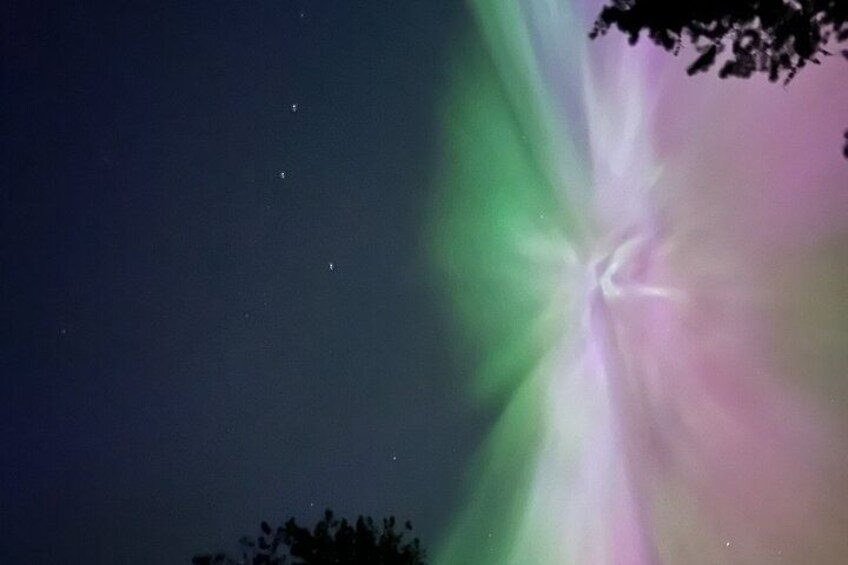 Un cielo notturno con un'aurora boreale verde e rosa. 4