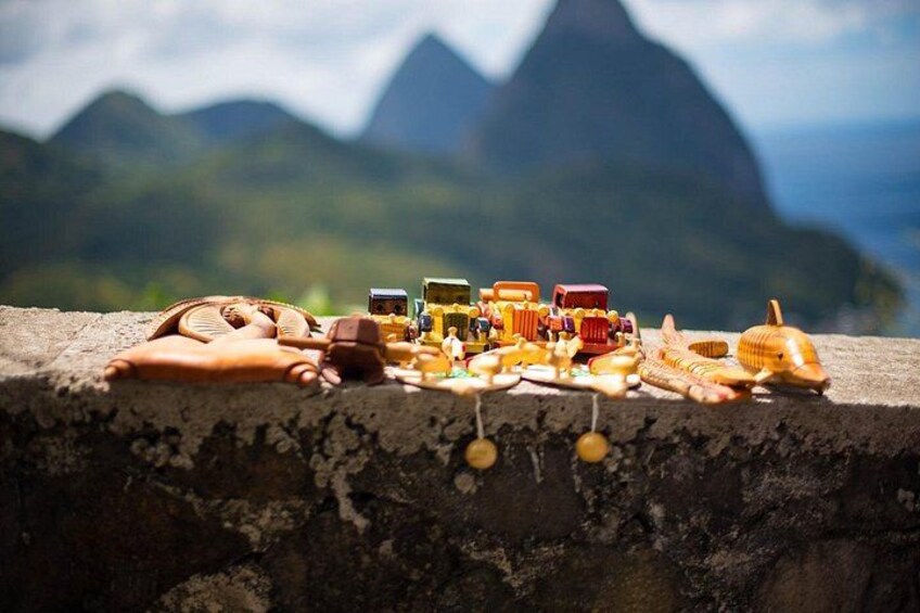 A collection of small toys and figurines on a concrete ledge with a mountainous landscape in the background. 3