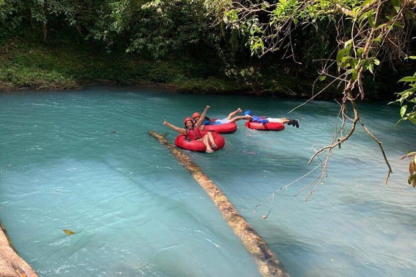 Personas flotando en un río dentro de tubos rojos. 5