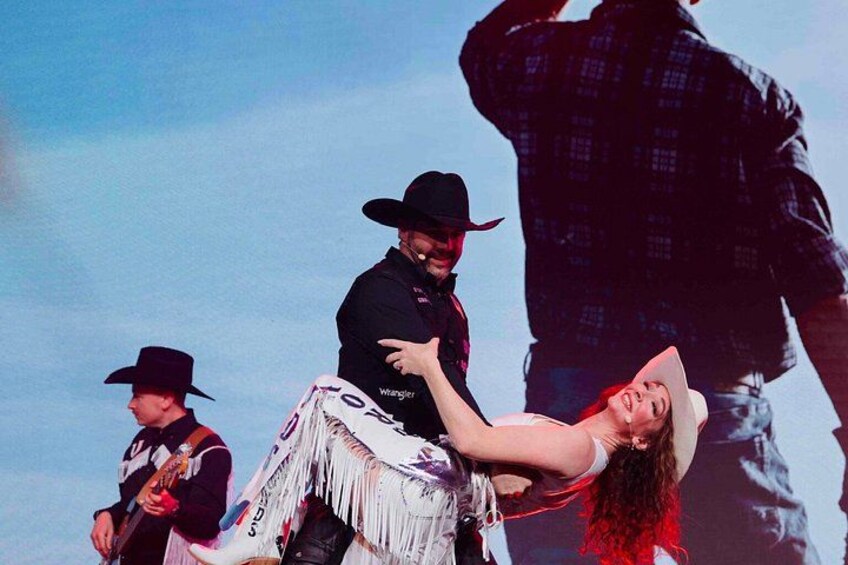 A person in a cowboy hat and a fringed outfit, another person in a black shirt and hat, and a third person in a plaid shirt. 1