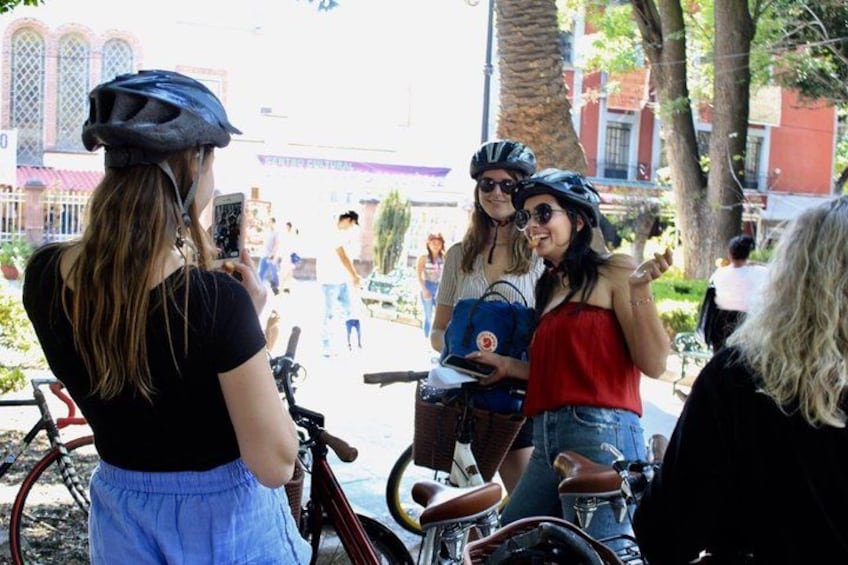 Un groupe de personnes à vélo, un vélo rouge et une personne tenant un téléphone intelligent. 1