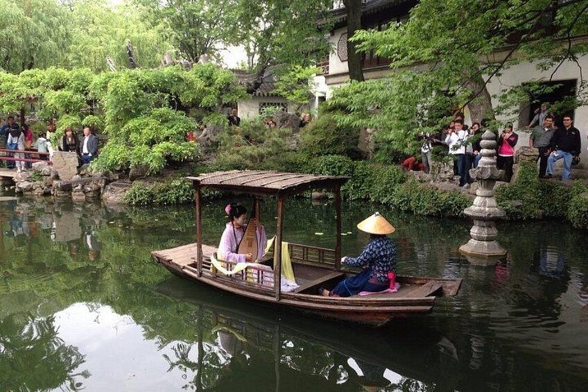A traditional boat with passengers, a calm river, and a stone lantern. 1