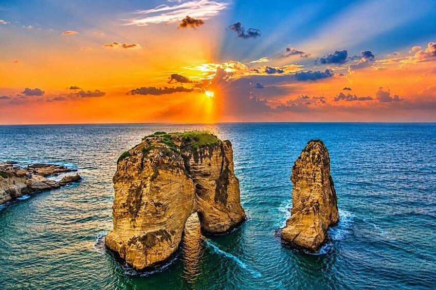 A coastal landscape with two prominent rock formations during sunset. 3