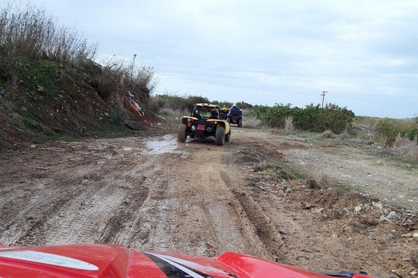 A dirt road with vehicles and a person. 2