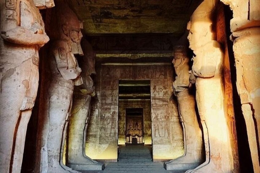 A stone corridor with ancient carvings and a central doorway. 2