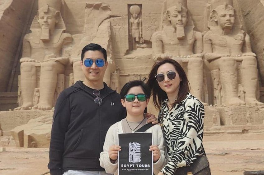 Three people standing in front of ancient Egyptian statues. 5