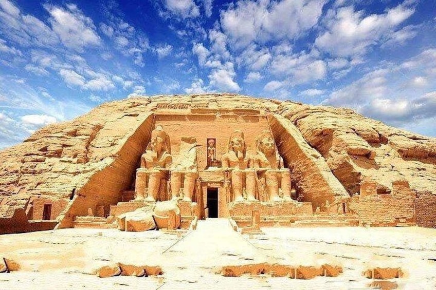 A large pyramid with a staircase leading to a temple entrance, surrounded by desert landscape. 4