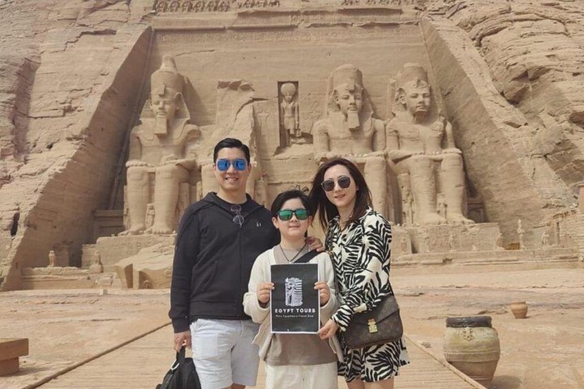 Een groep mensen voor een groot, oud Egyptisch tempel met hiërogliefen en beelden. 1
