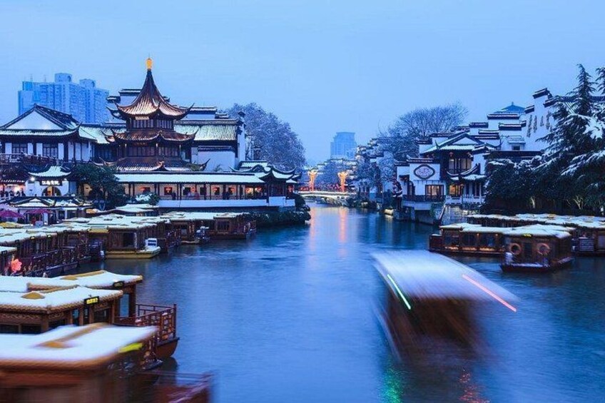 A river with traditional boats, buildings with Chinese architecture, and snow-covered trees. 5