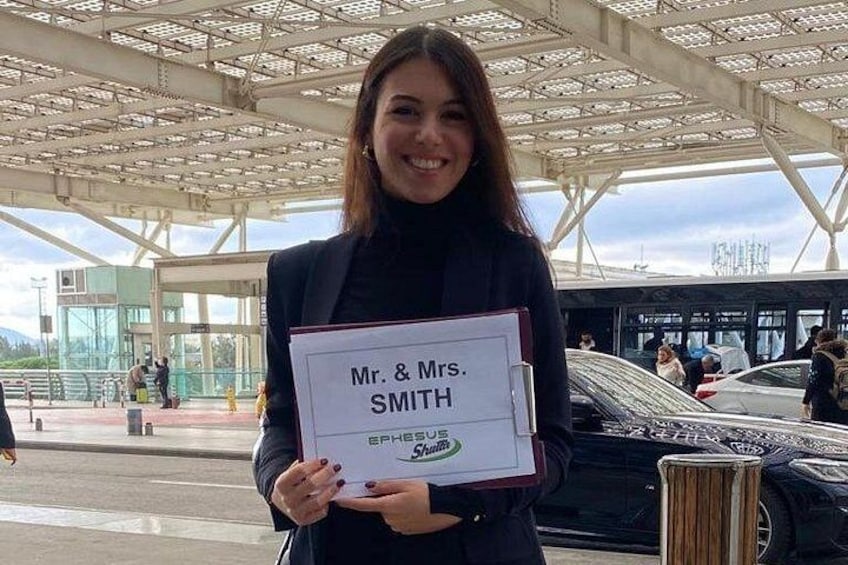 A person holding a sign with 'Mr. & Mrs. SMITH' and 'EPHESUS' on it. 5