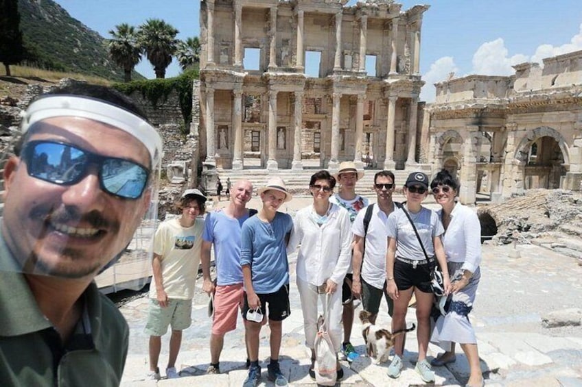A group of people standing in front of an ancient ruin with columns and arches. 4