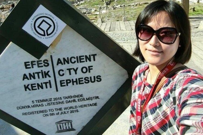 En person holder et skilt, der står 'EFES ANCIENT CITY OF EPHESUS' og nævner, at det er optaget på Verdensarvslisten den 5. juli 2015. 2