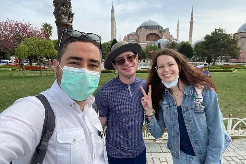 Trois personnes prennent un autoportrait devant un bâtiment historique. 2