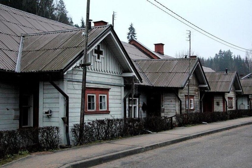 Una hilera de casas de madera con detalles rojos y techos de metal. 4