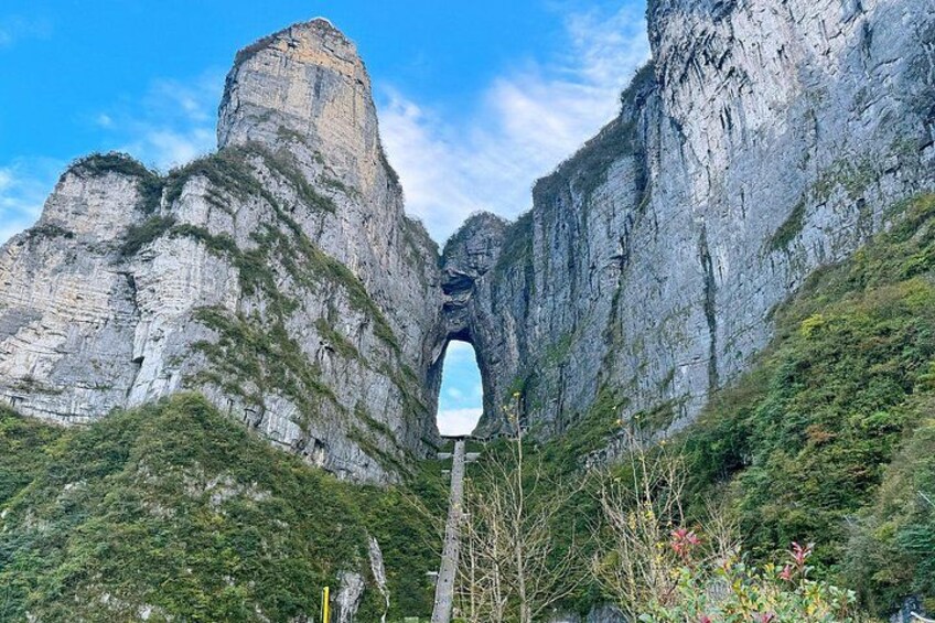 A mountain landscape with a prominent rock formation and a road leading through a valley. 4
