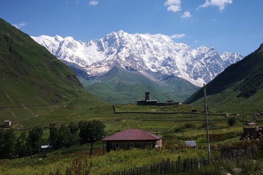 Un paysage montagneux avec une maison et des panneaux solaires. 3
