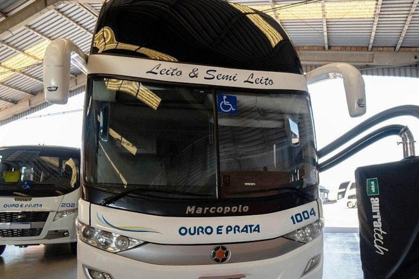 En bus med 'Leito & Semi Leito' og 'Marcopolo' branding, parkeret indendørs sammen med andre køretøjer. 3