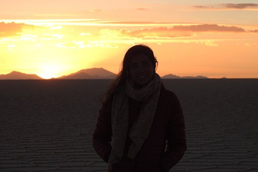 A person standing on a beach with a sunset in the background. 5