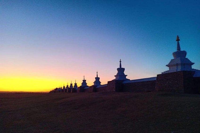 A row of white stupas against a sunset sky. 2