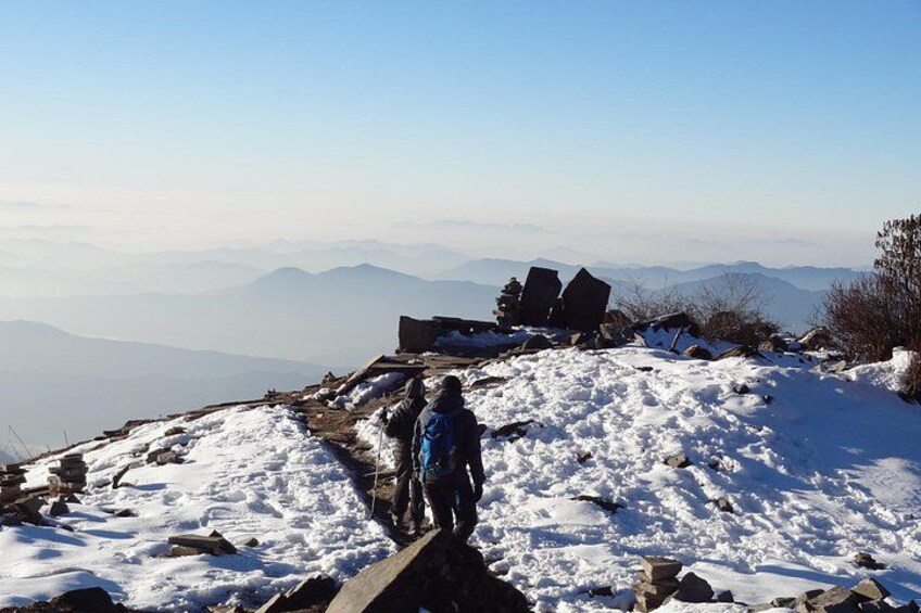 A snowy mountain path with a hiker and a wooden structure. 3