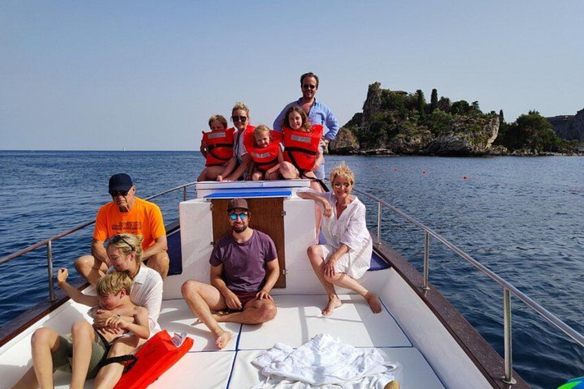 Un groupe de personnes se trouve sur un bateau, avec des falaises rocheuses en arrière-plan. 2