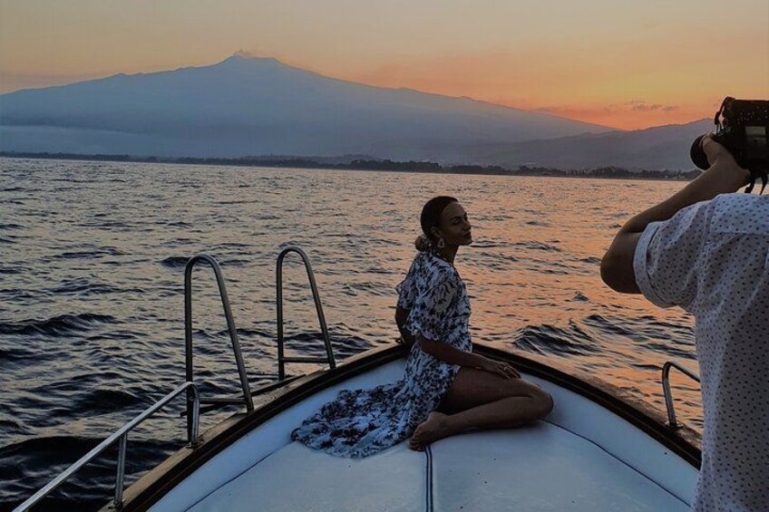 A person sitting on a boat with a mountain in the background. 5
